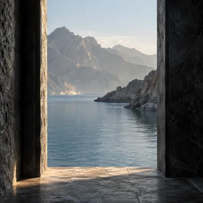 An open doorway framing still water and distant mountains